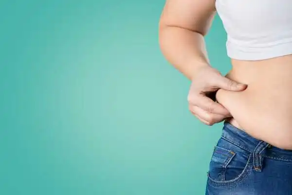 Image of woman pinching her love handles to show weight gain Kirkcaldy